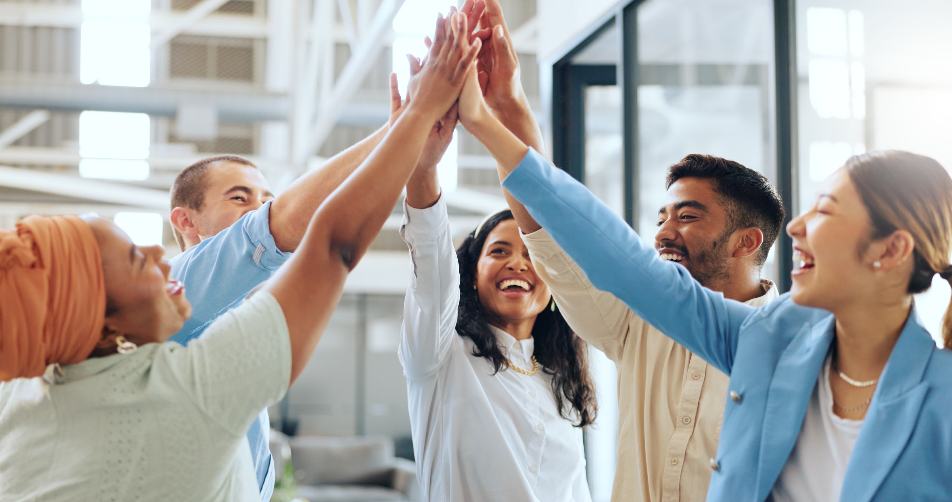 Colleagues celebrating together with raised hands